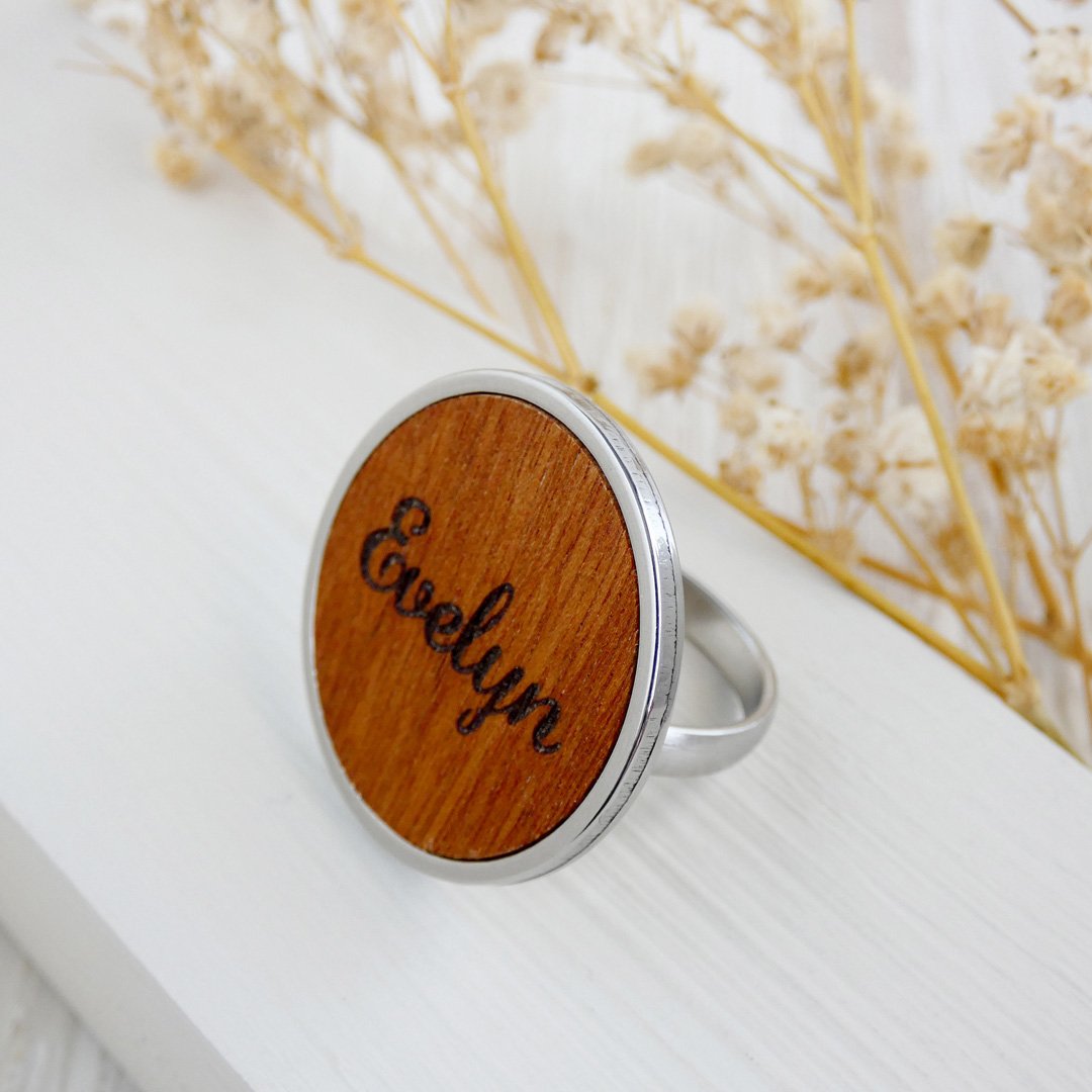 Anillo ajustable con un grabado personalizado sobre madera natural y con base acero inoxidable.