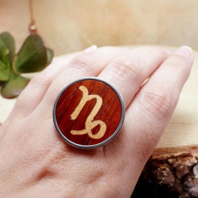 Anillo capricornio de madera ajustable mostrado en la mano