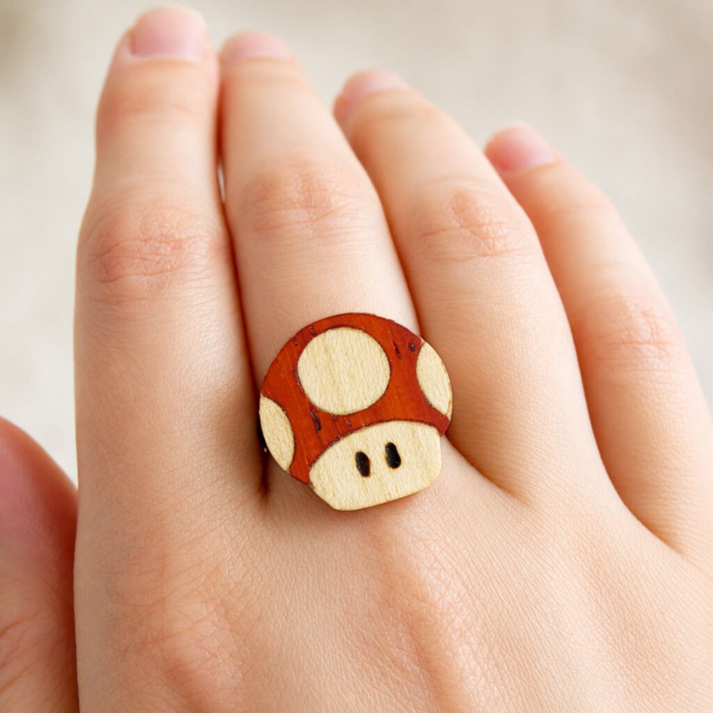 Anillo champiñón Mario de madera mostrado en la mano