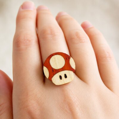 Anillo champiñón Mario de madera mostrado en la mano