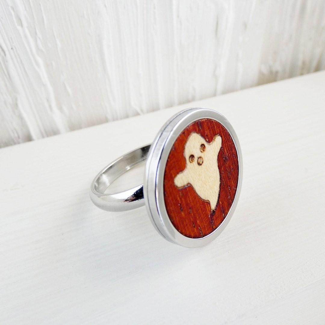 Anillo con fantasma de madera de sicomoro sobre fondo coral hecho a mano y base ajustable de acero inoxidable