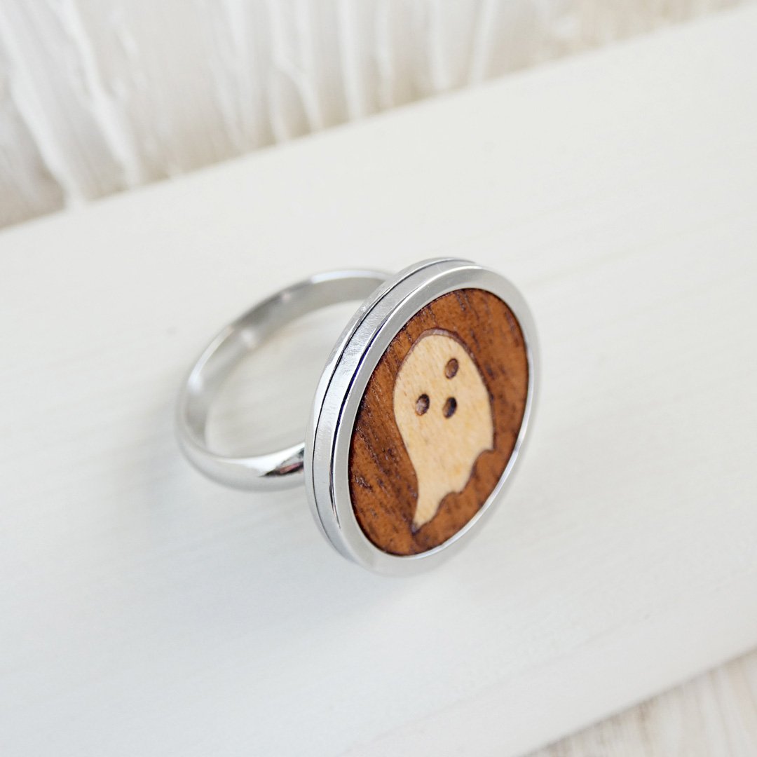 Anillo con fantasma de madera sobre fondo de nogal con base ajustable de acero inoxidable