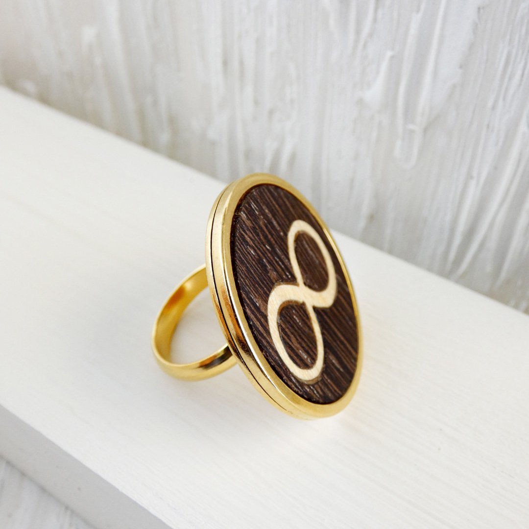 Anillo infinito con acabado dorado, con el símbolo de madera natural