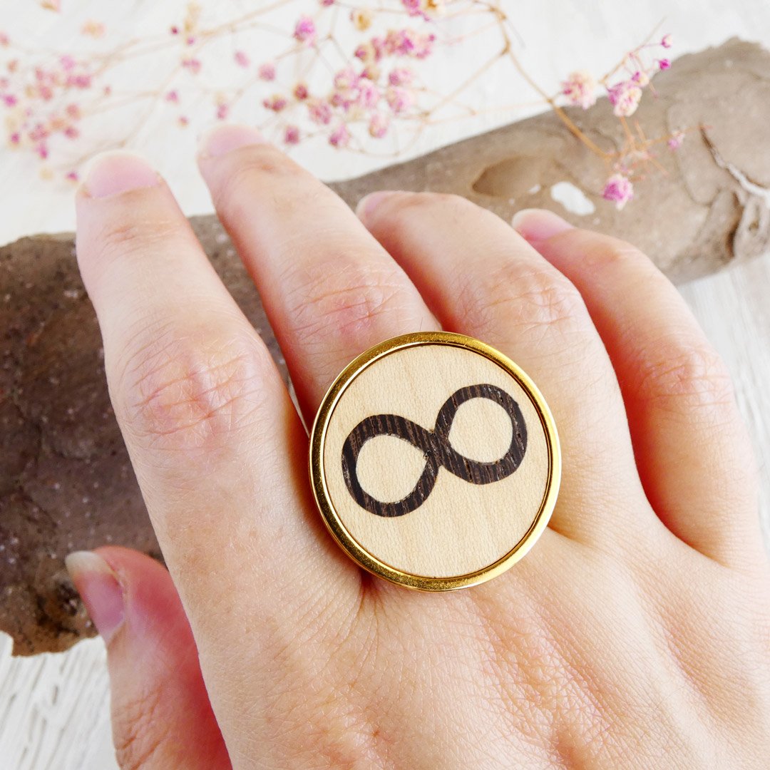 Anillo infinito ajustable de marquetería en madera de wengué y sicomoro puesto en la mano