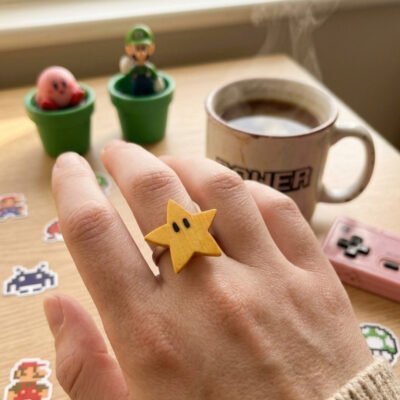 Anillo estrella de Mario en una fotografía lifestyle con decoración friki