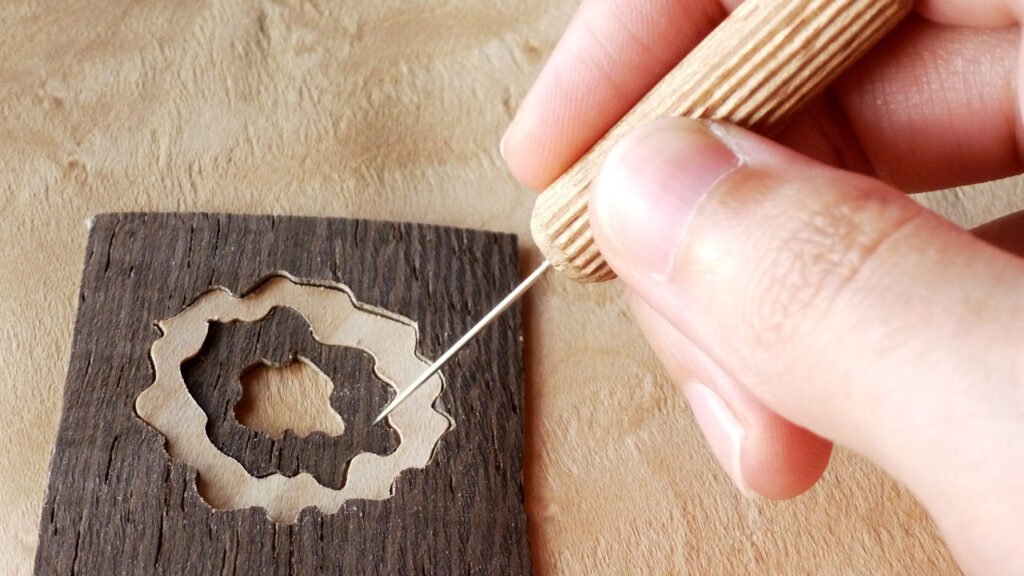 ChatGPT Plus
Photo showing a person's hands carefully assembling a small marquetry piece designed for a pendant. The image highlights the detail and precision required to fit the tiny wooden pieces together, creating a unique and artistic accessory.
