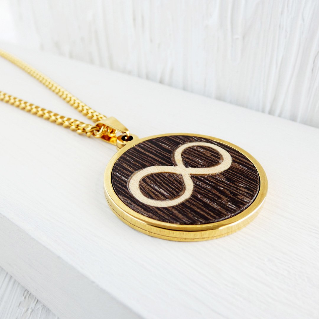 Colgante dorado con el símbolo infinito hecho a mano con madera de wengué y sicómoro