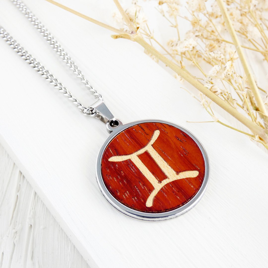 Colgante con el símbolo de Géminis hecho a mano en madera de coral y sicomoro.