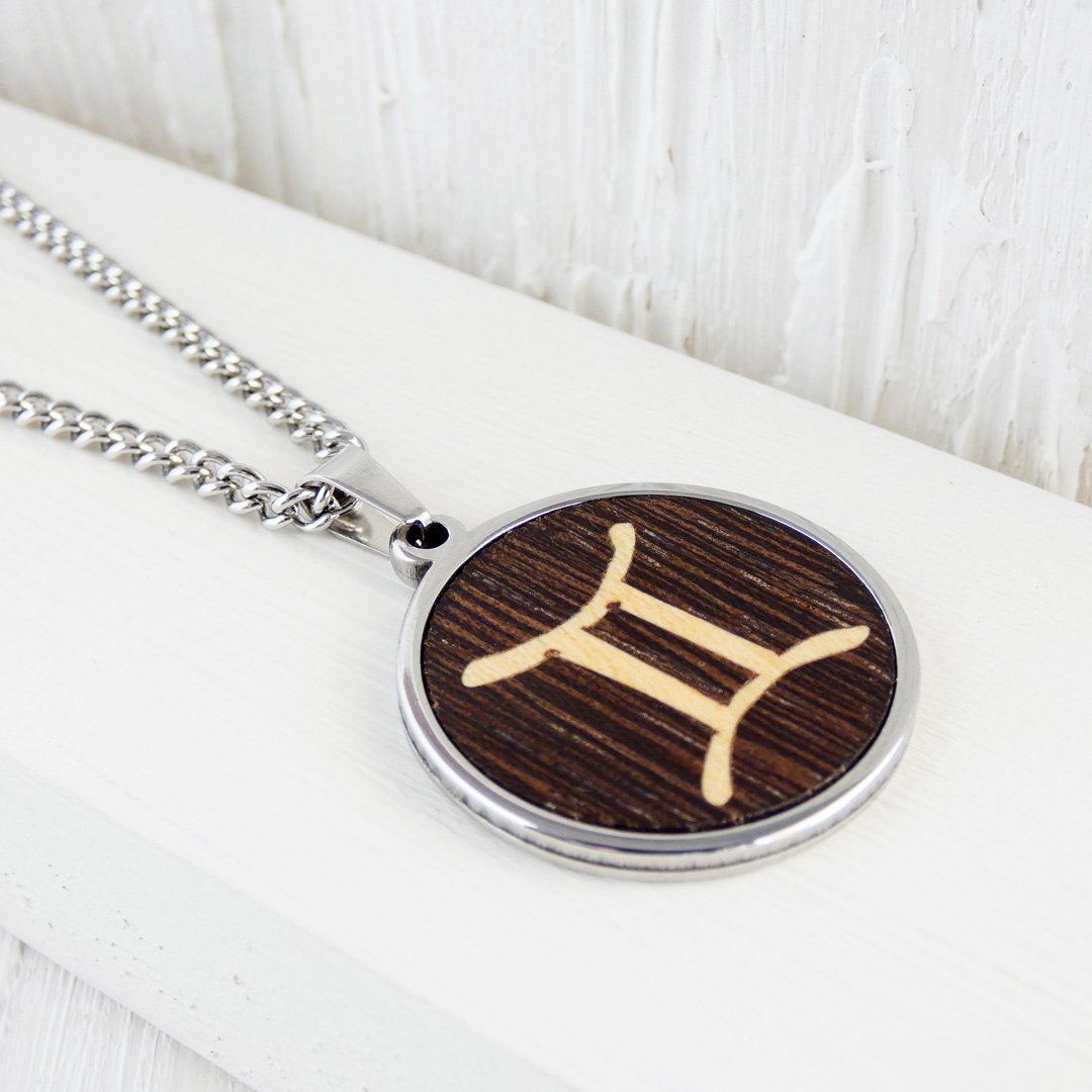 Collar artesanal con el símbolo de Géminis en madera de wengué con acabado de aceite natural.