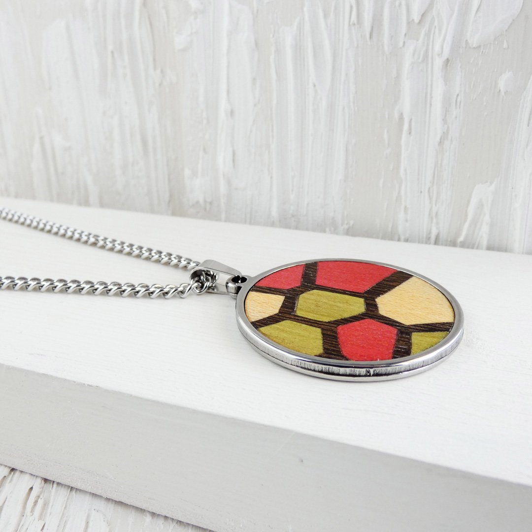 Colorido diseño de un colgante de madera inspirado en el Trencadís de Gaudí