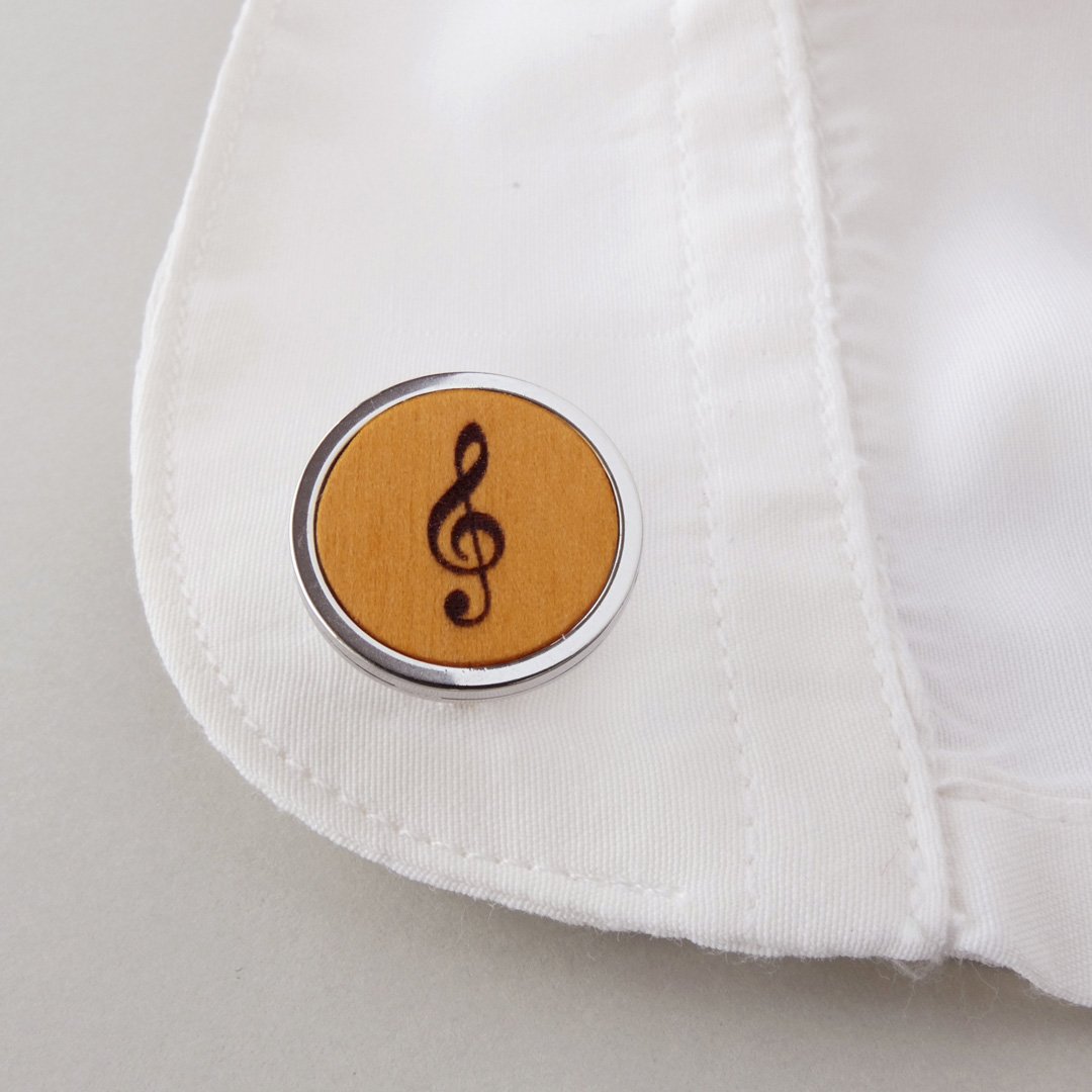 Gemelos de madera de boj en tono dorado con símbolo de clave de sol para bodas musicales.