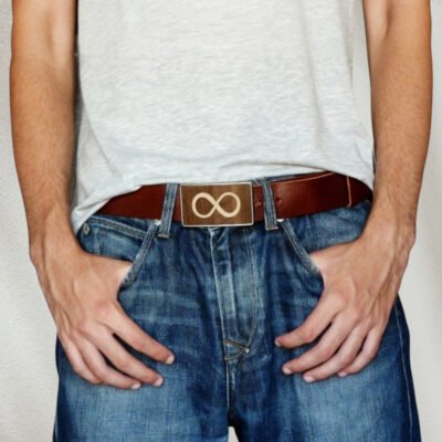 Hombre llevando hebilla de madera de infinito con vaqueros y estilo casual.