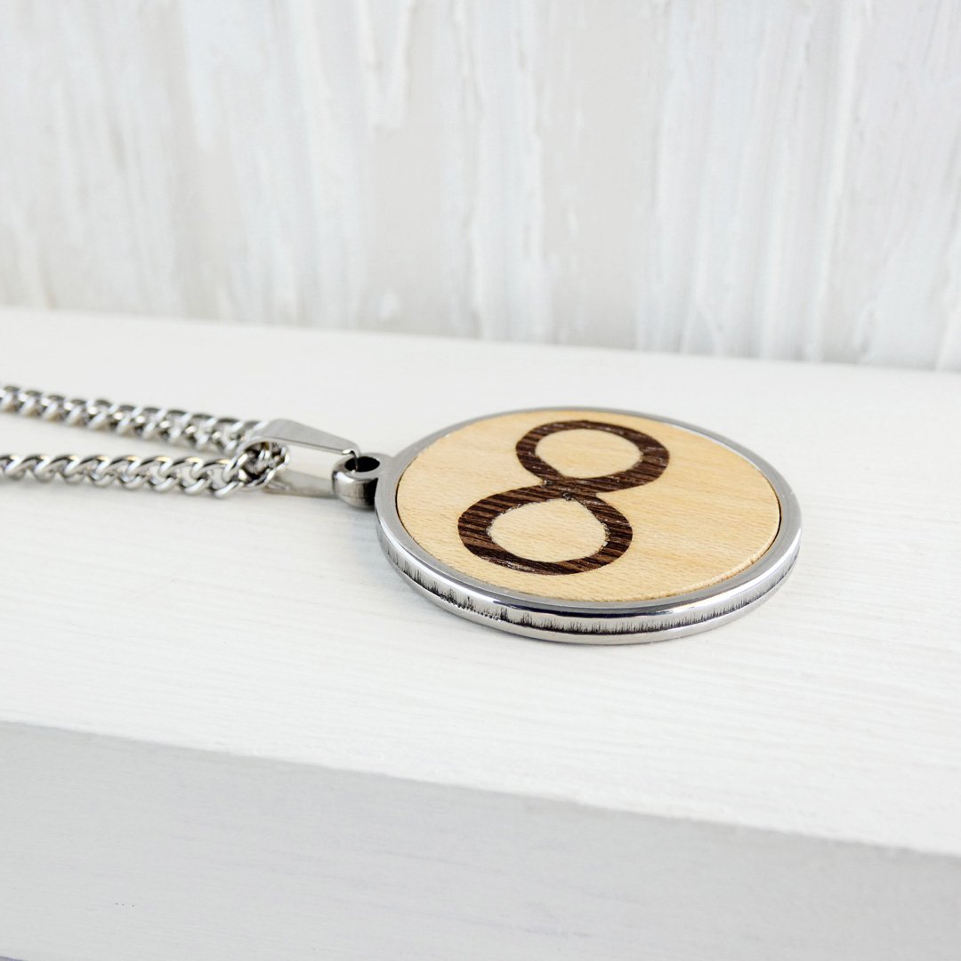 Diferentes maderas naturales como wengué y sicomoro en el diseño del infinito de este colgante.