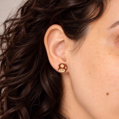 Pendientes champiñón de Mario de madera puestos en la oreja