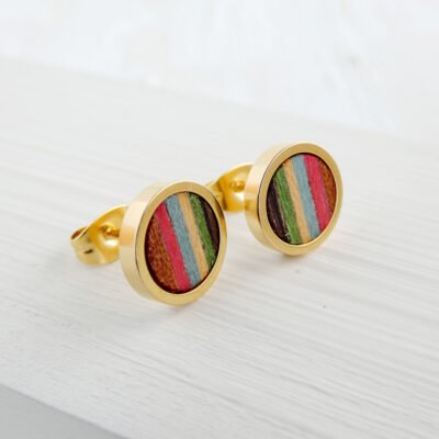 Primer plano de las vetas y texturas de los pendientes de colores de madera ensamblados a mano con la base dorada de acero inoxidable.