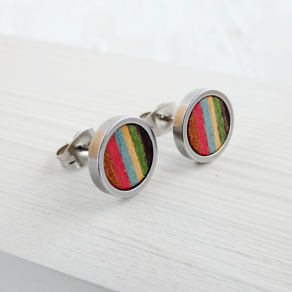 Pendientes de colores de madera natural y teñida, con una base acero inoxidable con diseño de tiras multicolor.