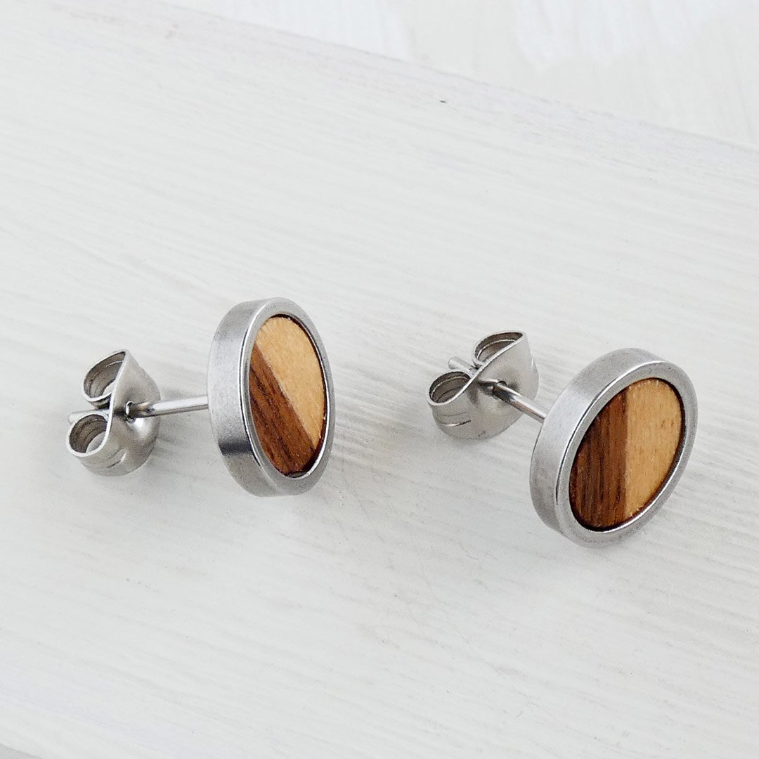 Poste de acero inoxidable en pendientes de madera de nogal y sicomoro para oídos sensibles.