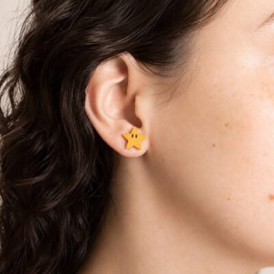 Pendientes de Mario Bros con estrella amarilla puestos en la oreja