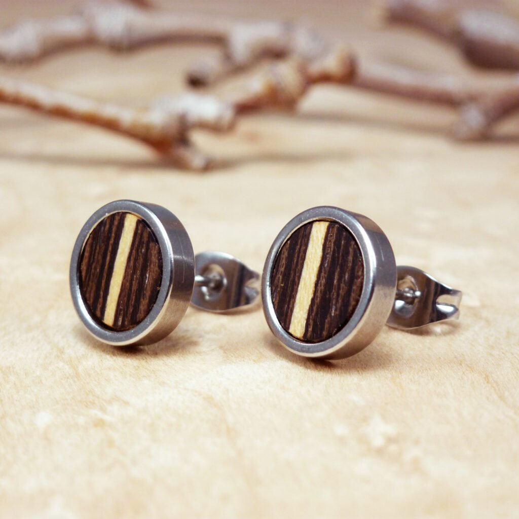 Pendientes redondos de madera de wengué con incrustaciones de sicomoro y base de acero inoxidable.